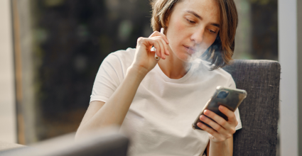 Personne qui vapote et regarde son téléphone