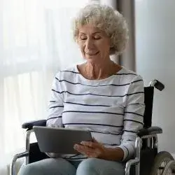 femme sénior handicapé avec une tablette