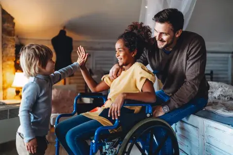 jeune fille en chaise roulante et heureuse avec sa famille