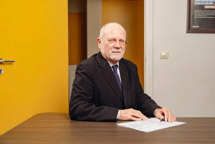 Henri lemoine assis avec porte jaune en arrière plan